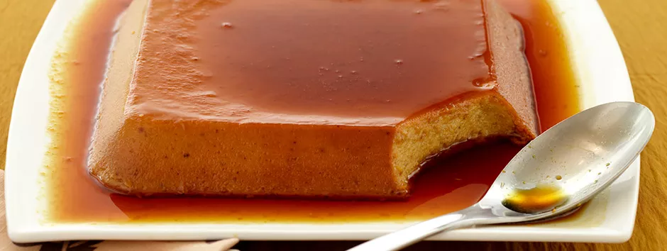 uma travessa braca com servindo um pudim de banana com cobertura caramelizada  