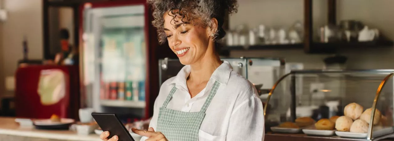 Empreendedora confere o fluxo de vendas em seu estabelecimento. Veja no infográfico como começar a empreender. 