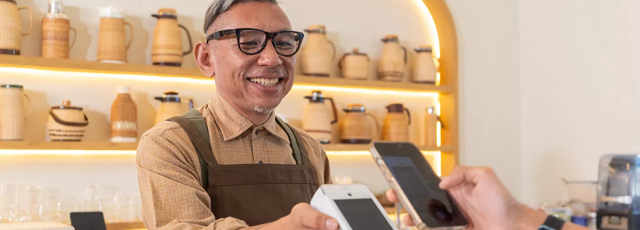 Dono de estabelecimento aceita pagamento com Pluxee Gift pelo smartphone do cliente 