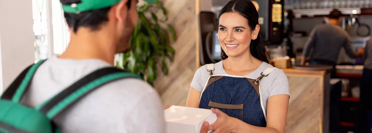 Empreendedora entrega mais uma refeição que será entregue pelo delivery 