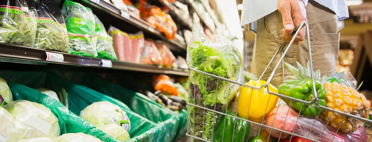 Pessoa escolhe verduras e legumes frescos em um supermercado