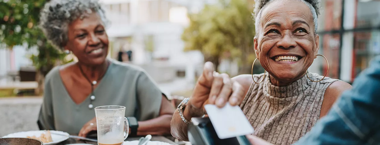 Duas mulheres utilizam pagamento por aproximação para pagar a conta do restaurante 