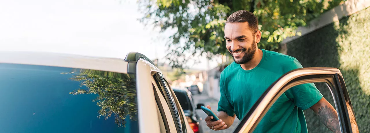 homem sorridentes entrando em seu carro. 