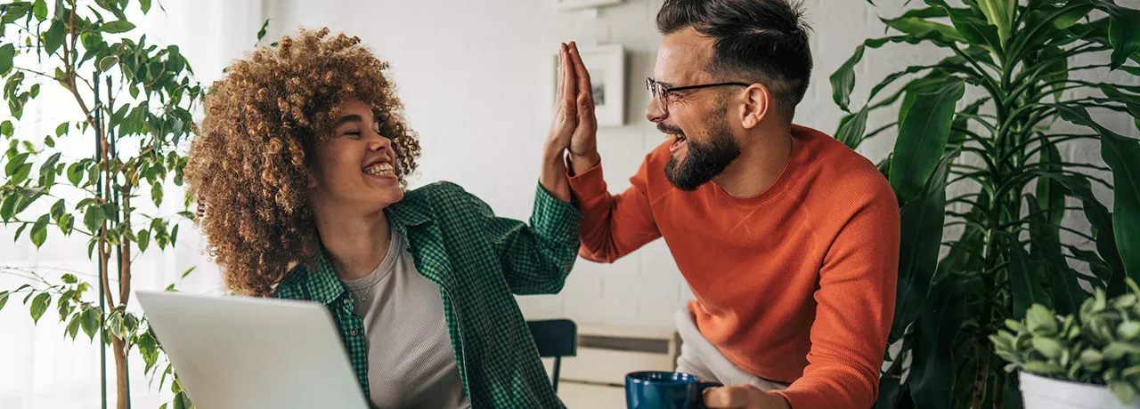 Dois colegas de trabalho comemoram o prêmio recebido pela Pluxee Brasil 