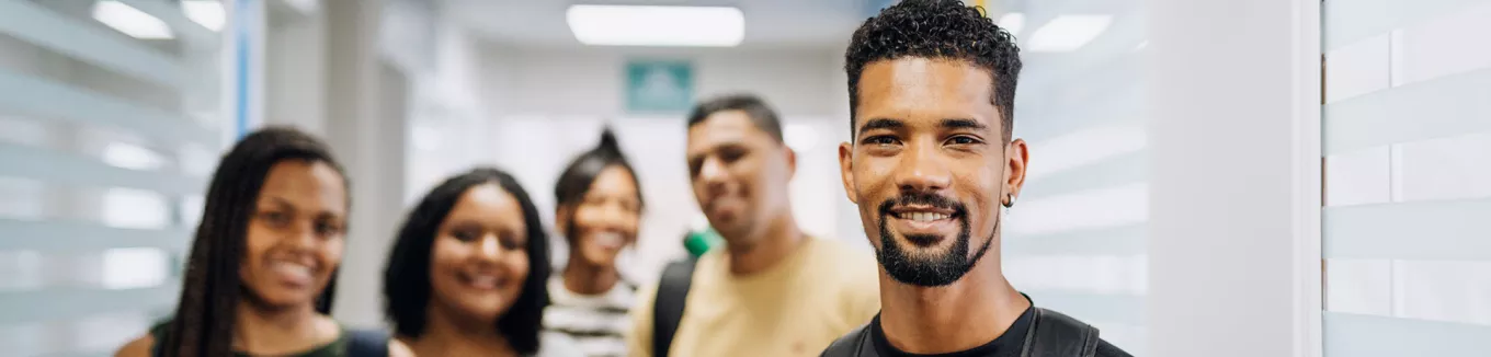 vários jovens sorrindo em ambiente corporativo. 