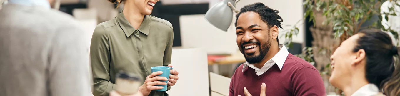pessoas sorrindo e conversando em ambiente corporativo. 