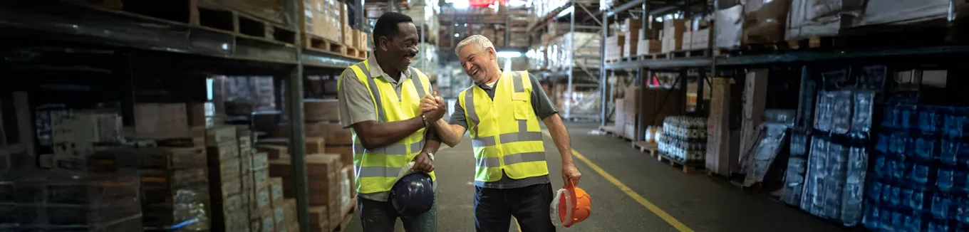 Foto mostra dois funcionários de uma empresa comemorando os resultados do final de ano 