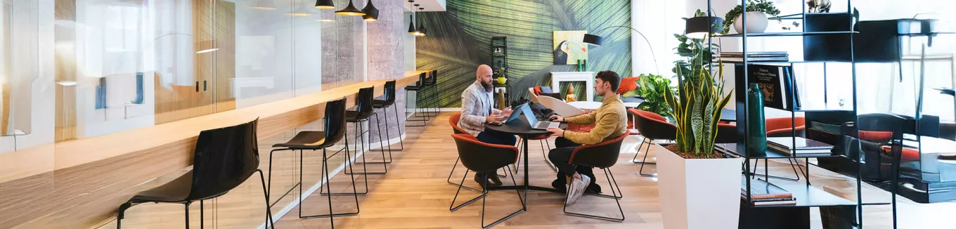 Imagem mostra duas pessoas em reunião no escritório 