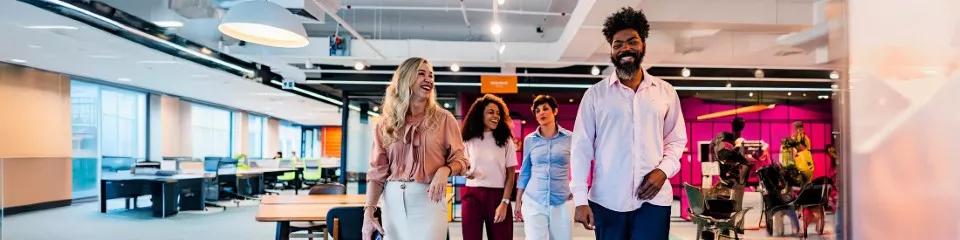 A imagem mostra uma mulher e um homem andando lado a lado em uma loja 