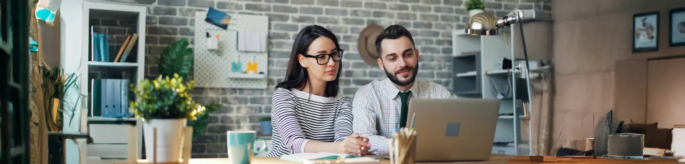 Foto mostra um chefe trabalhando uma pessoa de sua equipe