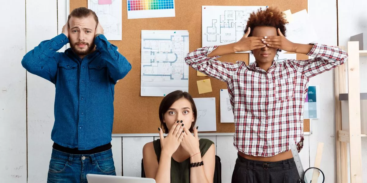 três pessoas imitando os “três macacos sábios”, da cultura japonesa. 