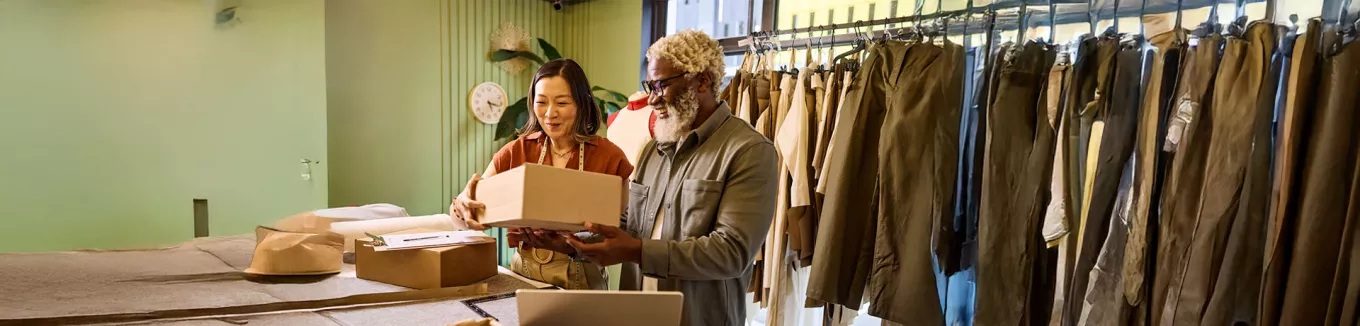 Microempresária trabalha com seu funcionário na loja de roupas 