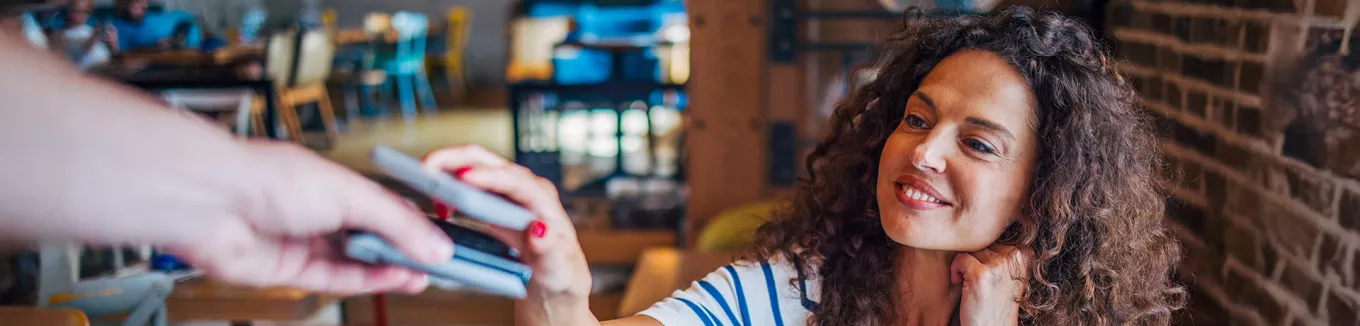 mulher pagando compra com celular. 