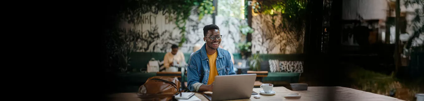 homem sorrindo enquanto usa o notebook. 