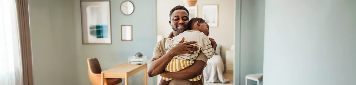 pai segurando o filho no colo. 