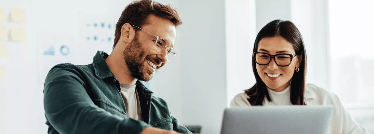 Homem e mulher em um ambiente corporativo, sorrindo