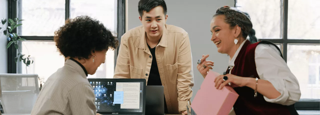 homem e duas mulheres conversando em ambiente de trabalho 