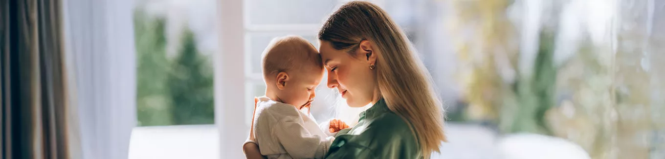 mulher com a testa encostada em seu neném.