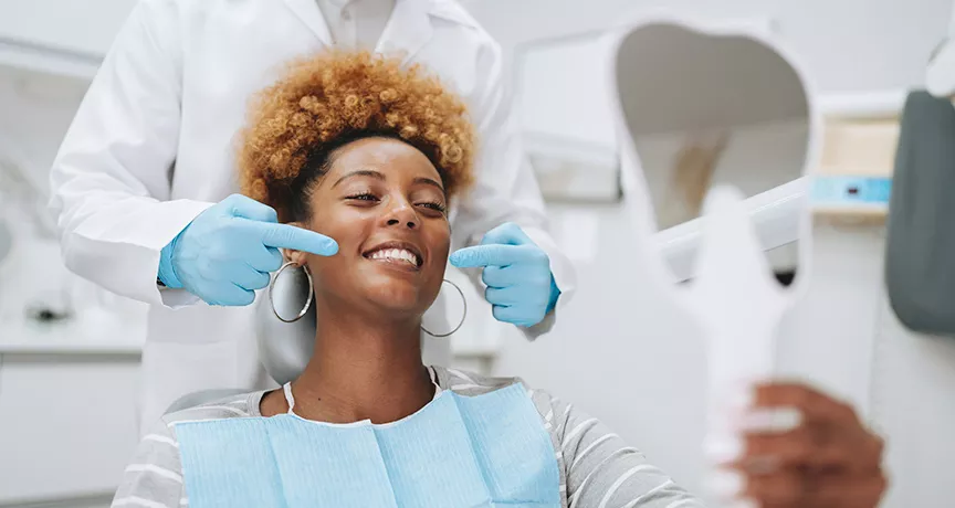mulher sorrindo na cadeira de dentista.