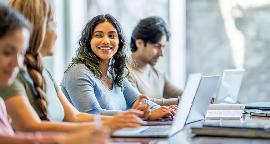 mulher sorrindo para companheiros de estudos.