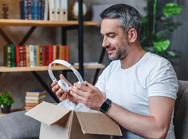 Funcionário recebe o fone de ouvido que comprou com Pluxee Gift