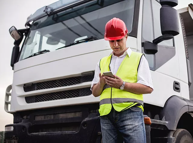 Motorista de caminhão acessa o app Pluxee Frota no seu celular