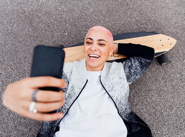 Foto mostra uma mulher usando seu smartphone