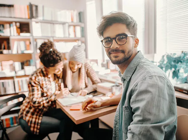 Foto mostra time trabalhando junto em um escritório