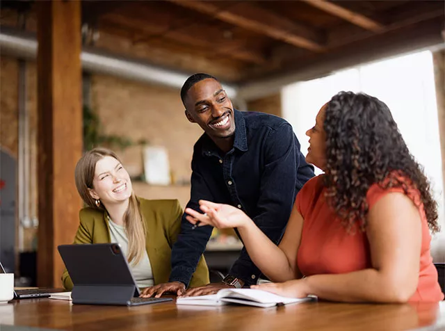 Três profissionais trabalham juntos no planejamento de 2026 do RH