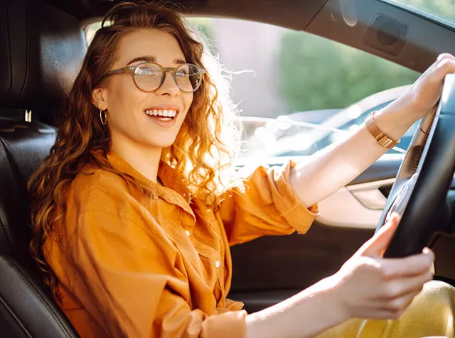 Foto mostra uma representante comercial dirigindo a trabalho