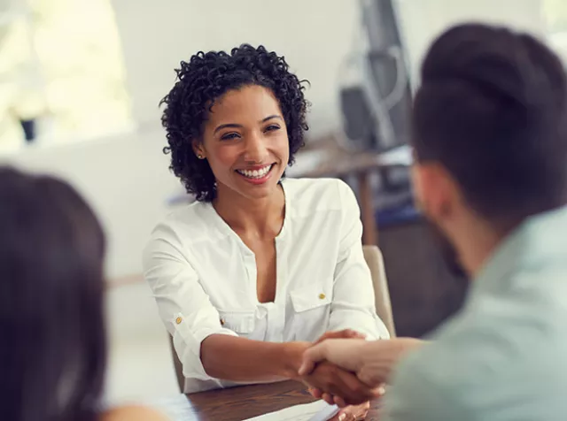 mulher sorrindo enquanto faz a admissão de profissional.