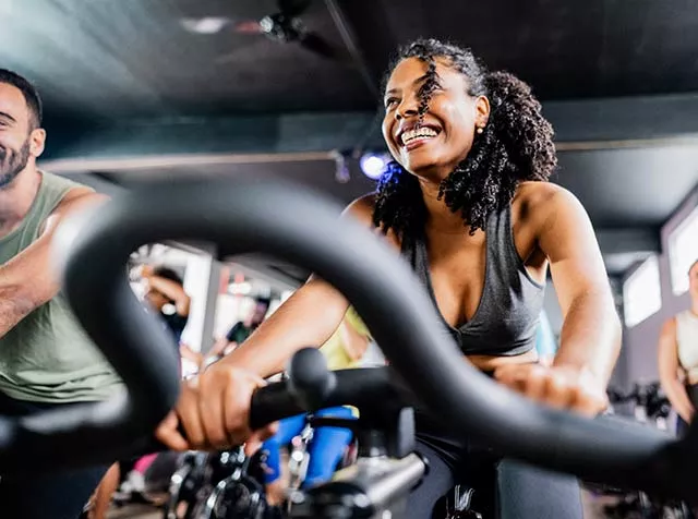 Mulher faz aula de spinning usando o plano Wellhub