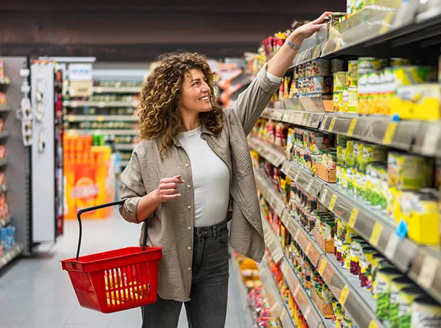 Foto de uma mulher escolhendo produtos no supermercado