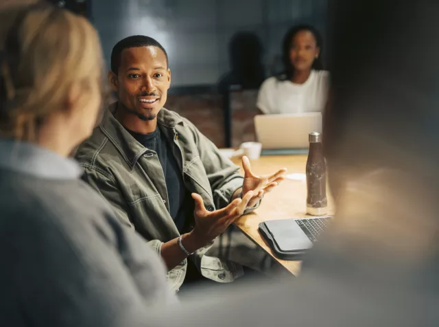 Profissionais participando de reunião colaborativa em ambiente corporativo, tema abordado na pesquisa Trabalho: um refúgio em tempos de mudanças da Pluxee + Ipsos 2026