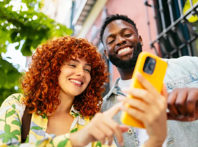 Pessoas utilizando smartphone em ambiente urbano, representando conectividade e os insights da pesquisa sobre trabalho, engajamento e inteligência artificial