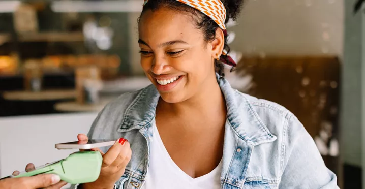 Mulher paga conta em café usando seu cartão Pluxee no Apple Pay