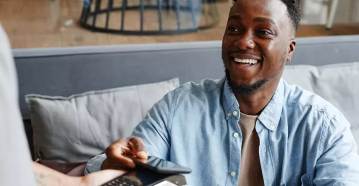 Homem paga conta com vale-refeição Pluxee no seu restaurante favorito