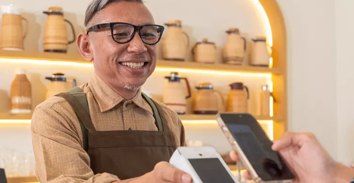 Dono de estabelecimento aceita pagamento com Pluxee Gift pelo smartphone do cliente