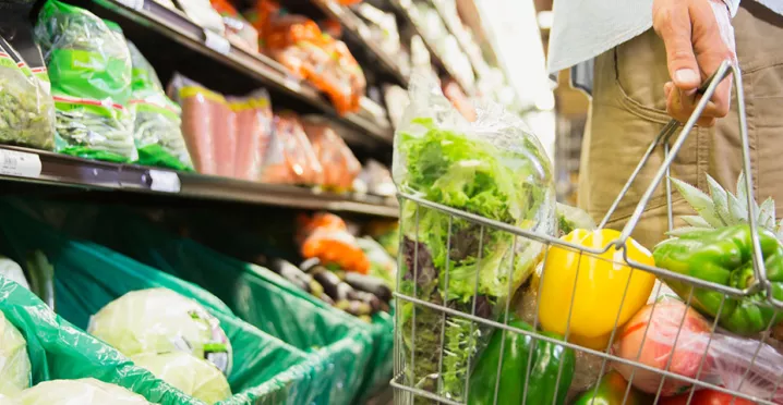 Pessoa escolhe verduras e legumes frescos em um supermercado