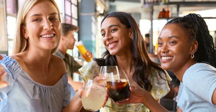 Foto mostra 3 amigas tirando uma foto juntas no restaurante