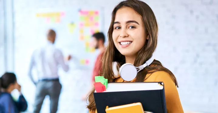 Jovem profissional está no escritório levando material para sua reunião