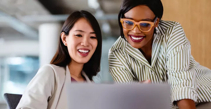 Duas colegas de trabalho contribuem para a evolução de um projeto na empresa