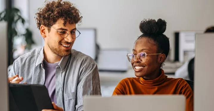 Dois colegas de trabalho veem juntos o andamento de um projeto