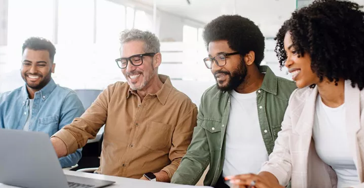 Equipe de quatro pessoa trabalha junta em um escritório