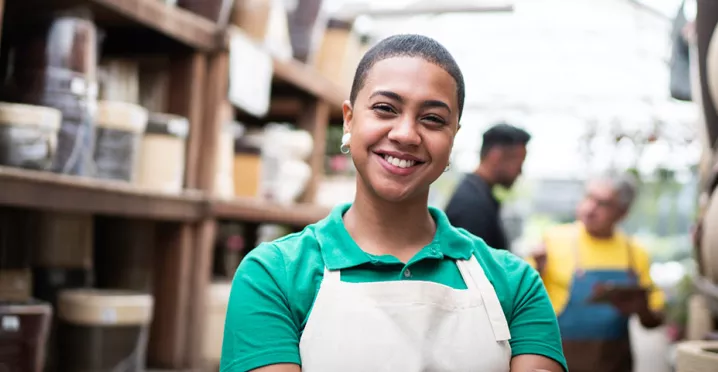 Foto mostra funcionária de uma loja de cerâmicas sorrindo para a câmera