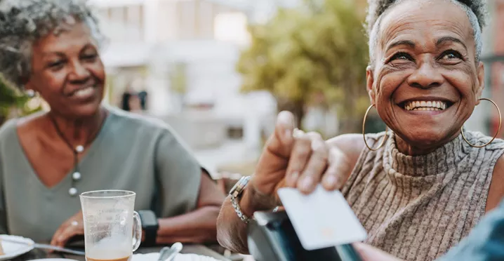 Duas mulheres utilizam pagamento por aproximação para pagar a conta do restaurante
