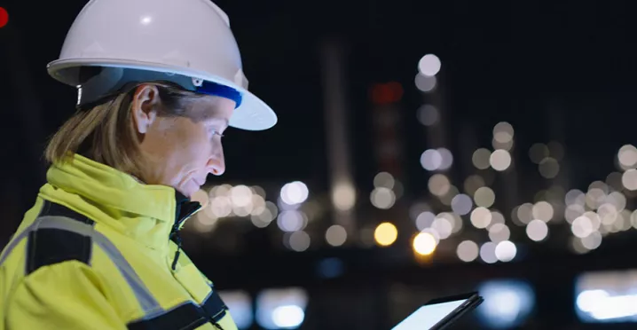 profissional com capacete de proteção trabalhando à noite.