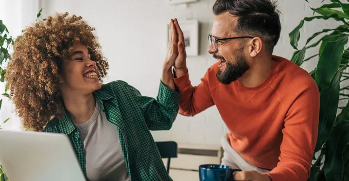 Dois colegas de trabalho comemoram o prêmio recebido pela Pluxee Brasil