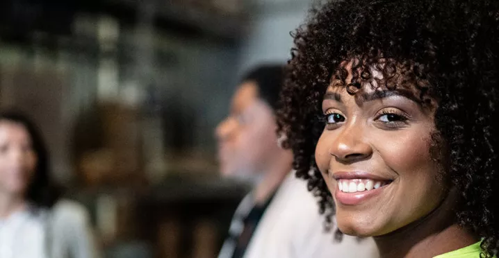 Profissional sorri na fábrica em que trabalha