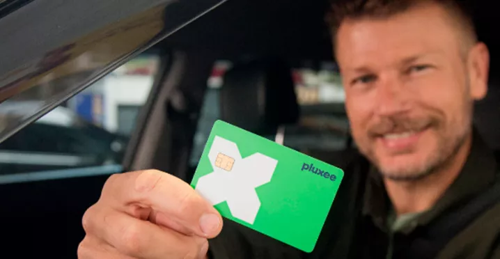 Rodrigo Hilbert dirigindo com o cartão Pluxee na mão